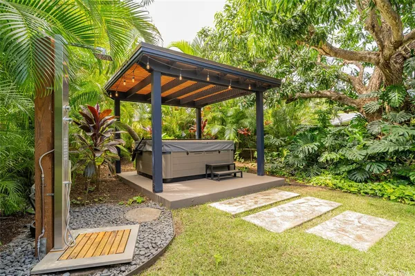 a view of a patio with table and chairs under an umbrella with a small yard