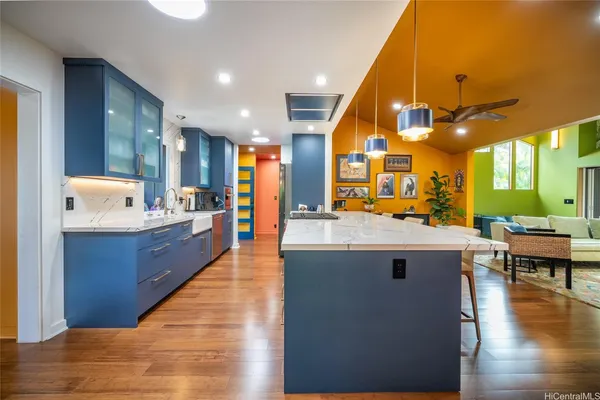 a living room with stainless steel appliances kitchen island granite countertop a sink and cabinets