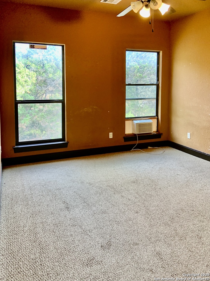 19940 Scenic Loop Road San Antonio, TX 78255 - Photo 13 of 34 an empty room with windows