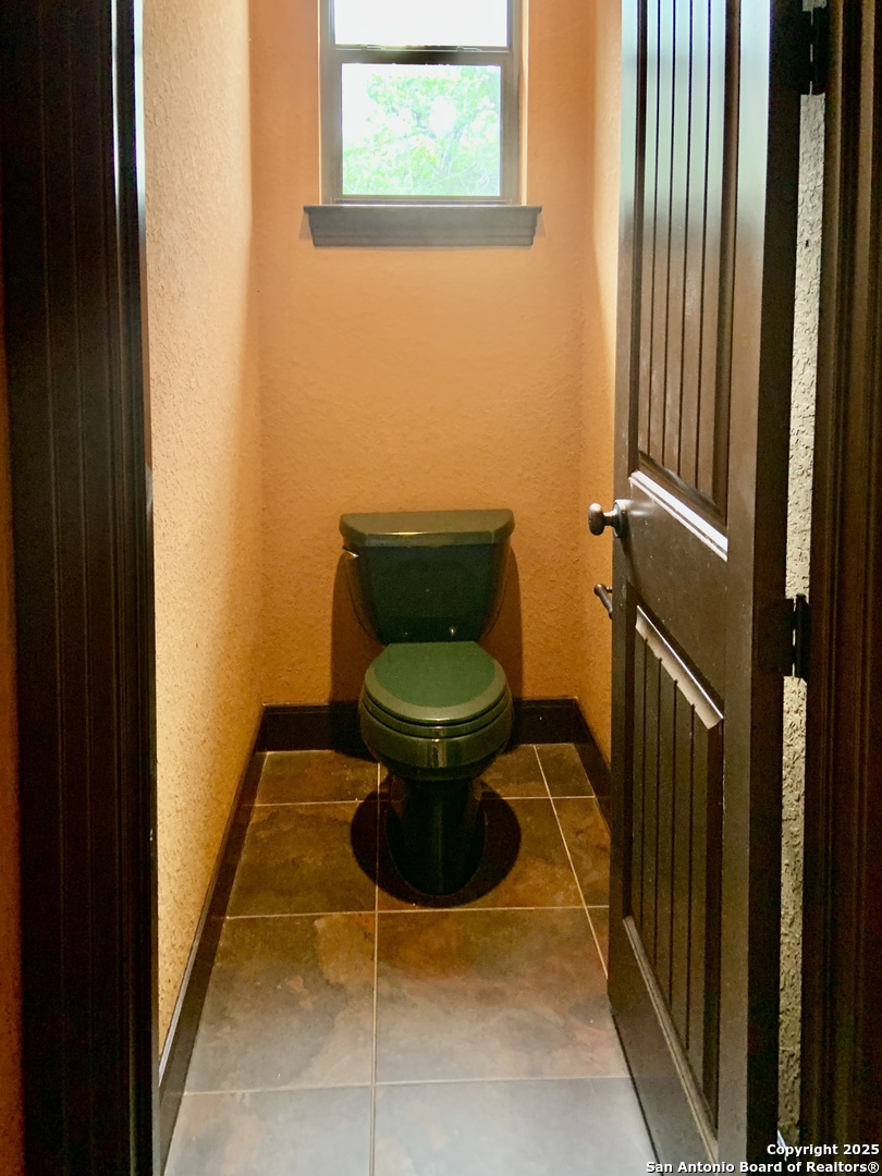 19940 Scenic Loop Road San Antonio, TX 78255 - Photo 20 of 34 a bathroom with a toilet and a sink