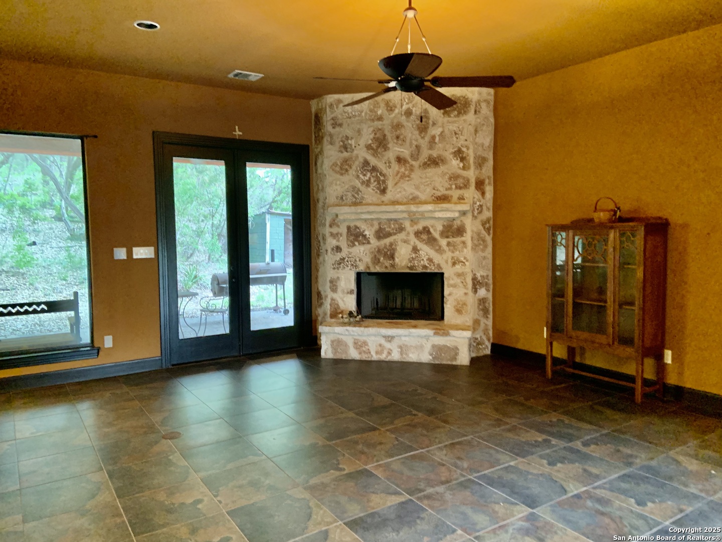 19940 Scenic Loop Road San Antonio, TX 78255 - Photo 5 of 34 a view of an empty room with a fireplace and a window