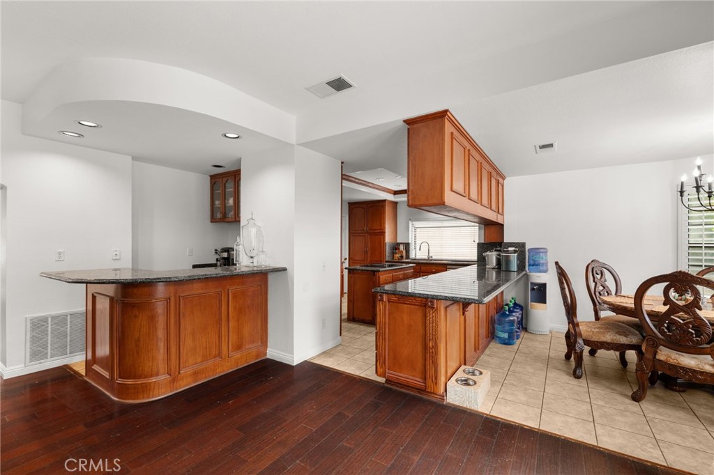 12732 Arena Drive Rancho Cucamonga, CA 91739 - Photo 14 of 61 a kitchen with stainless steel appliances granite countertop a stove a sink dishwasher and a dining table with wooden cabinet