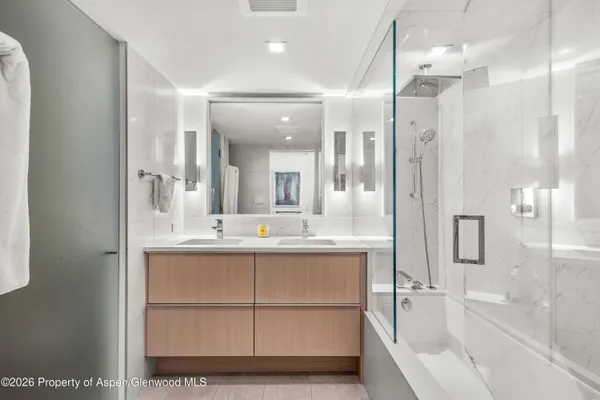 a bathroom with a tub sink shower and mirror