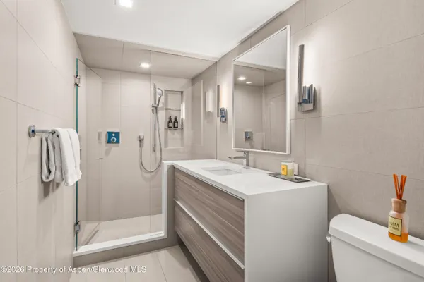a bathroom with a sink a toilet and shower
