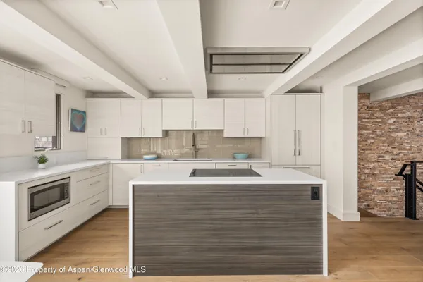 a kitchen with a stove cabinets and wooden floor