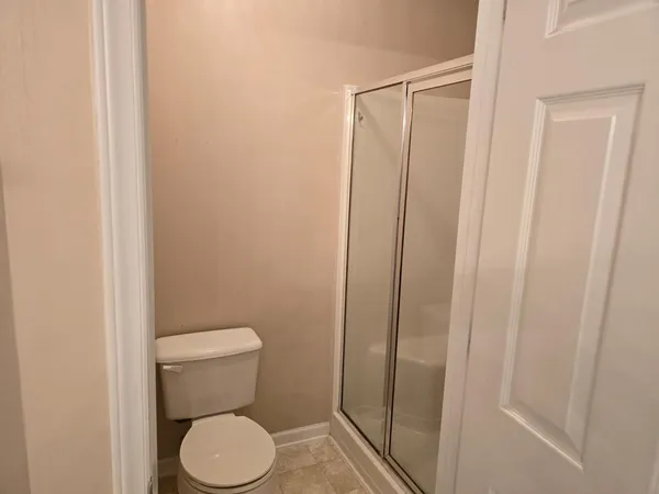 a white toilet sitting next to a shower