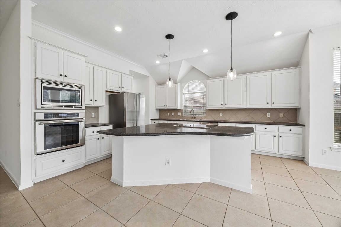 12507 Aliso Bend Lane Houston, TX 77041 - Photo 2 of 25 a kitchen with stainless steel appliances granite countertop a sink a stove a microwave and a refrigerator