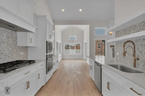 a large kitchen with stainless steel appliances granite countertop a lot of counter space and a sink