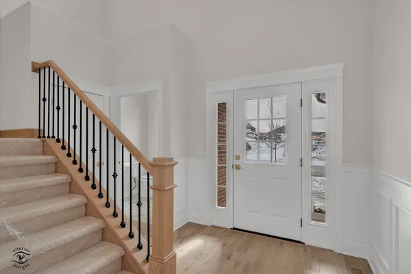 a view of a hallway with wooden floor and entryway