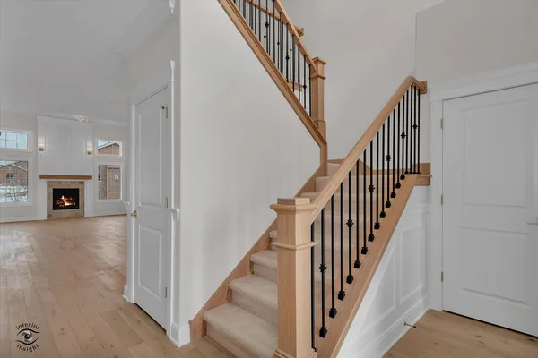a view of a hallway with wooden floor and staircase
