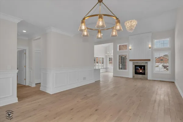 an empty room with wooden floor mirror and window