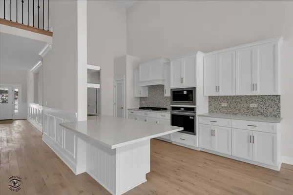 a large kitchen with cabinets and wooden floor