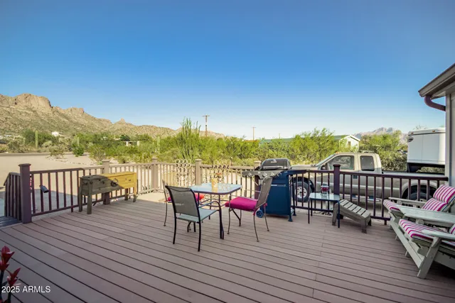 a view of a rooftop deck with chairs and wooden floor