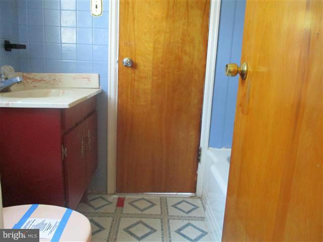 1717 Leslie Road Baltimore, MD 21222 - Photo 13 of 18 a bathroom with a granite countertop sink and a mirror