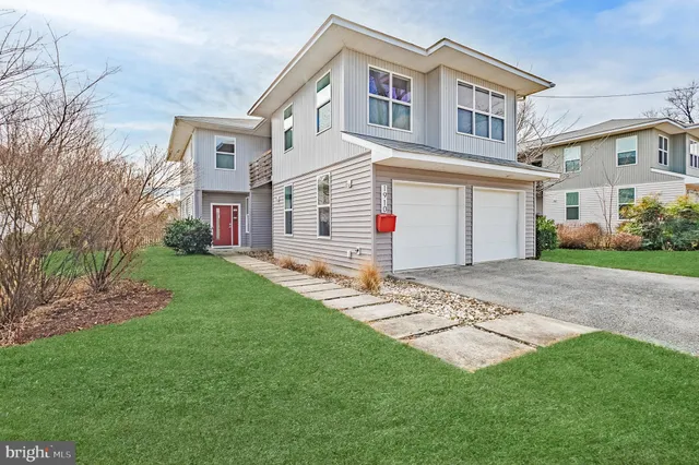 a front view of a house with a garden and plants