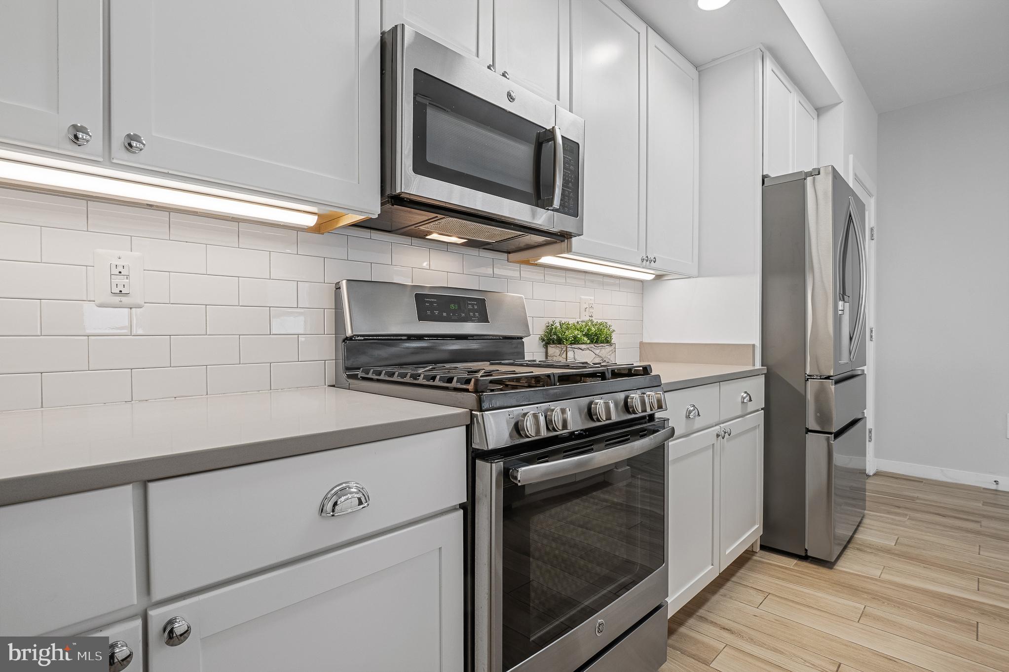 1910 Plyers Mill Road Silver Spring, MD 20902 - Photo 27 of 106 a kitchen with stainless steel appliances a stove microwave and refrigerator