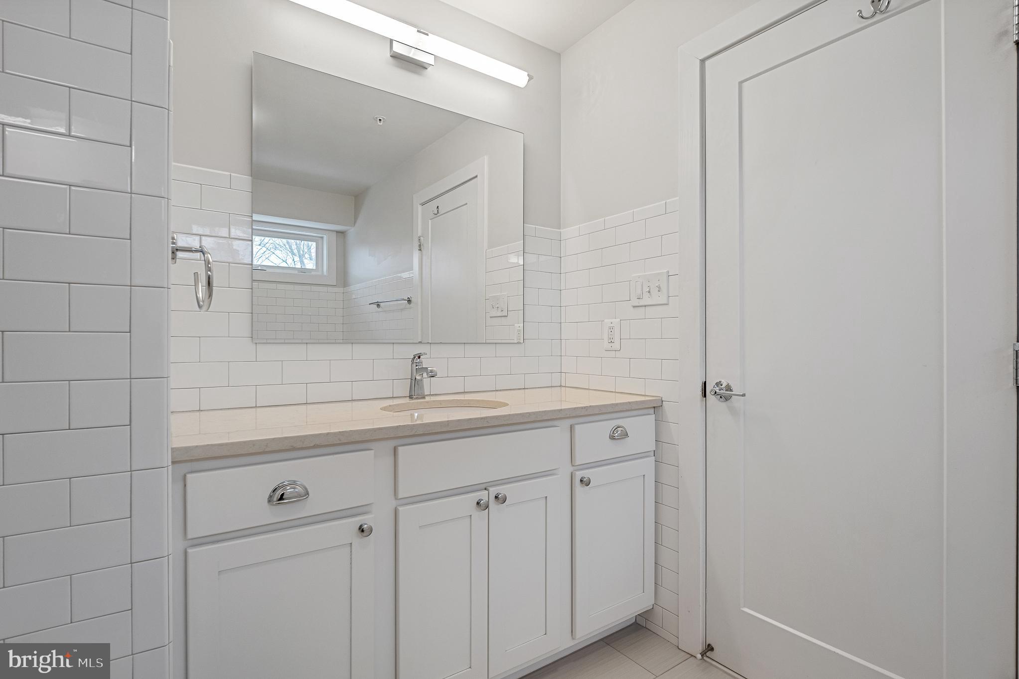 1910 Plyers Mill Road Silver Spring, MD 20902 - Photo 83 of 106 a bathroom with a granite countertop sink and a mirror