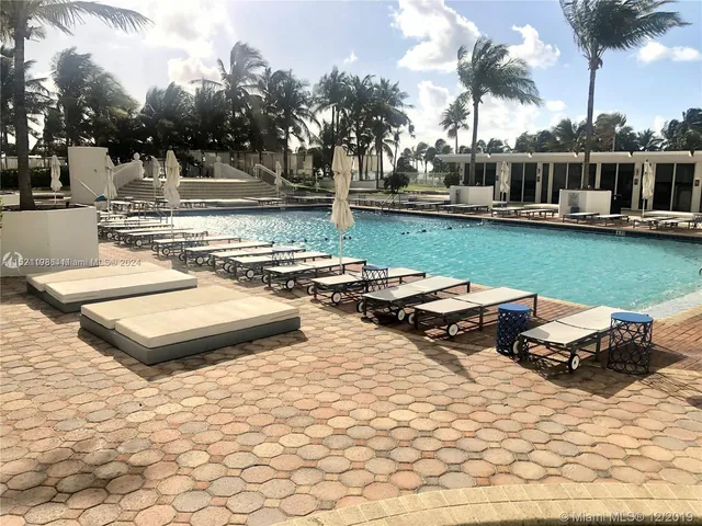 a view of a swimming pool and lounge chairs in the patio