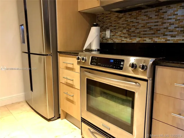 a stove top oven sitting inside of a kitchen