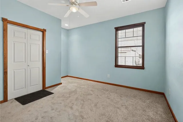 an empty room with windows and fan