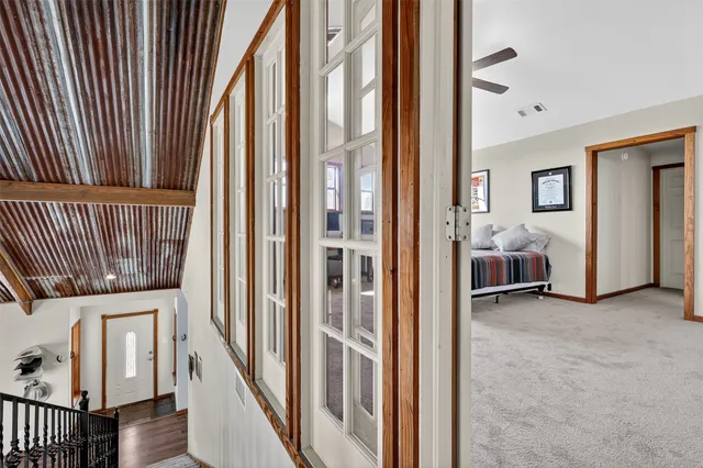 a view of a hallway with staircase and white walls