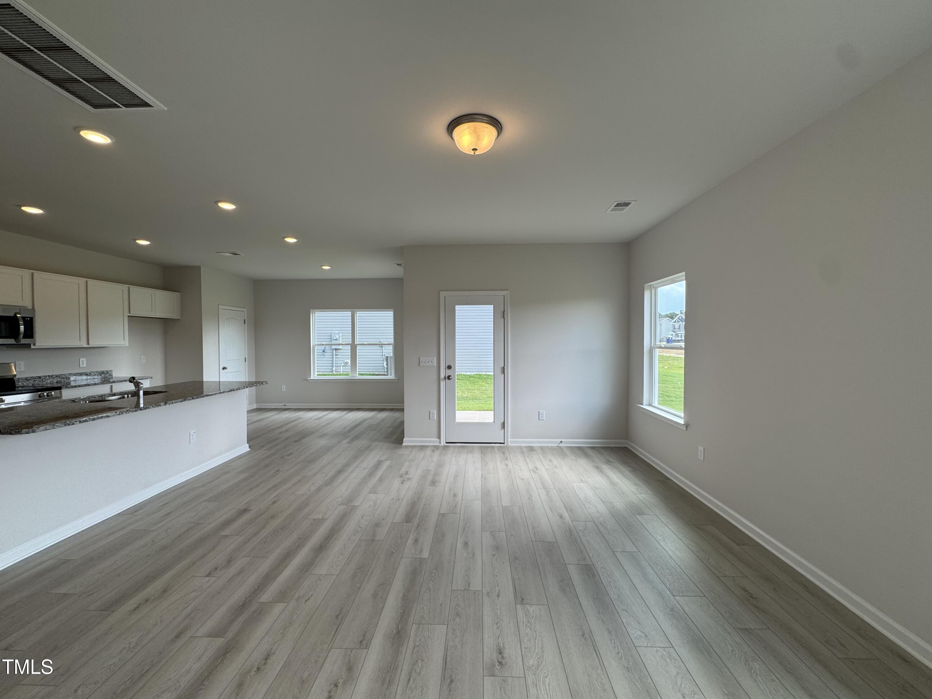 184 Bruce Drive Dunn, NC 28334 - Photo 7 of 32 a view of an empty room with window and wooden floor