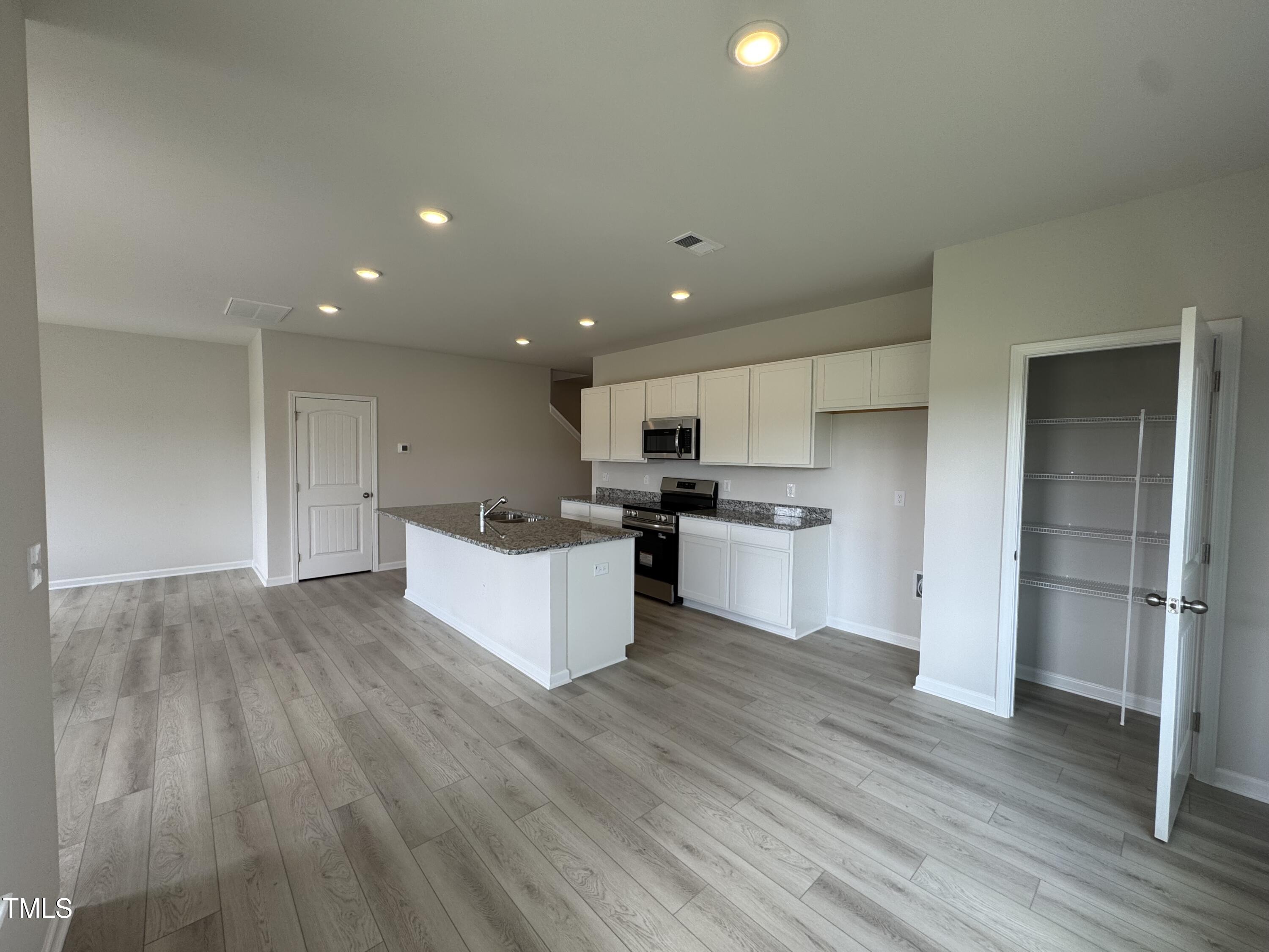 184 Bruce Drive Dunn, NC 28334 - Photo 9 of 32 a large kitchen with a lot of counter top space stainless steel appliances and a wooden floor