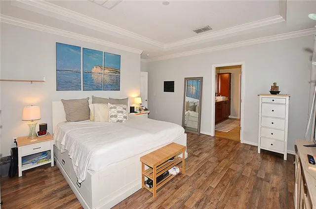 a spacious bedroom with a bed and a dresser