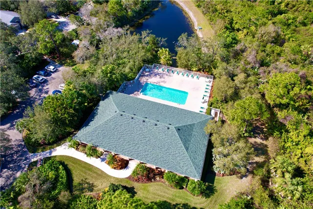 an aerial view of residential house with outdoor space and trees all around