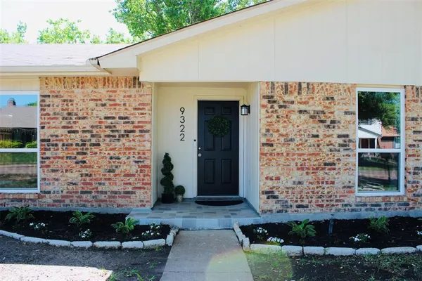 a front view of a house with a plants