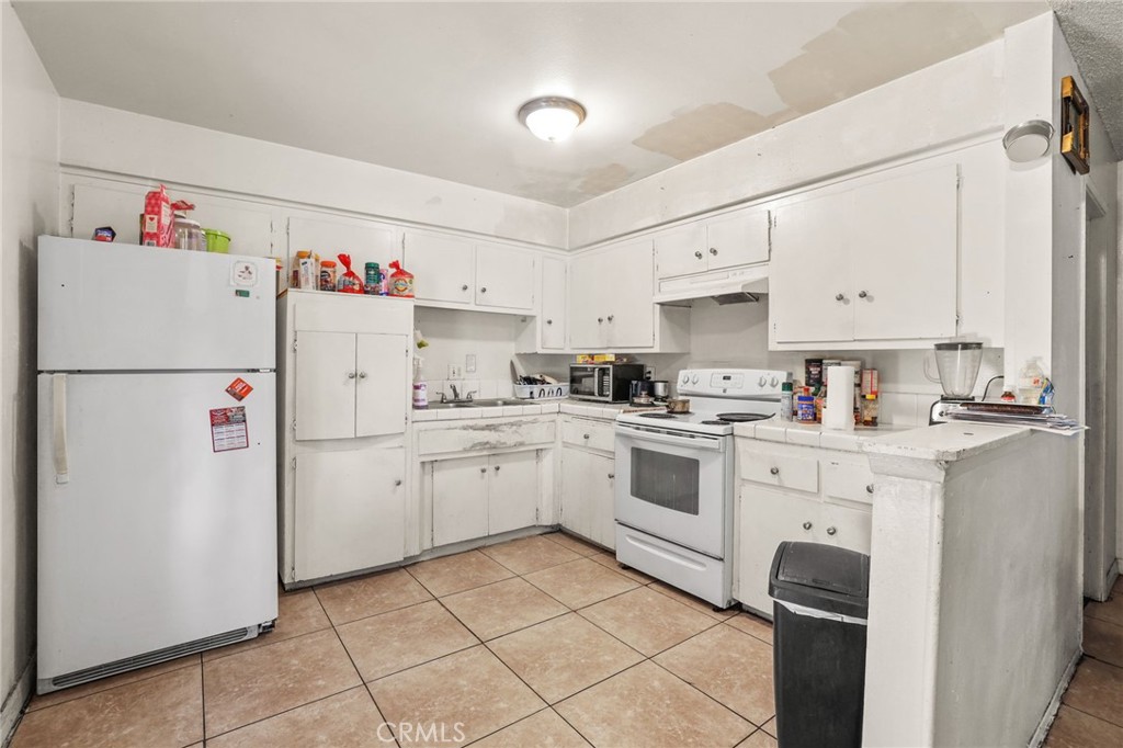 2601 Andover Avenue Fullerton, CA 92831 - Photo 5 of 14 a kitchen with a white refrigerator a sink dishwasher and a refrigerator with wooden cabinets