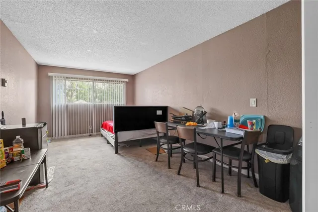 a living room with furniture a flat screen tv and a window