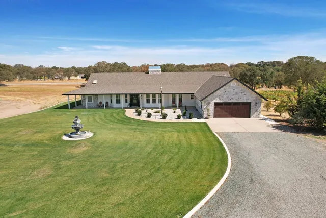 an aerial view of a house with swimming pool garden and lake view