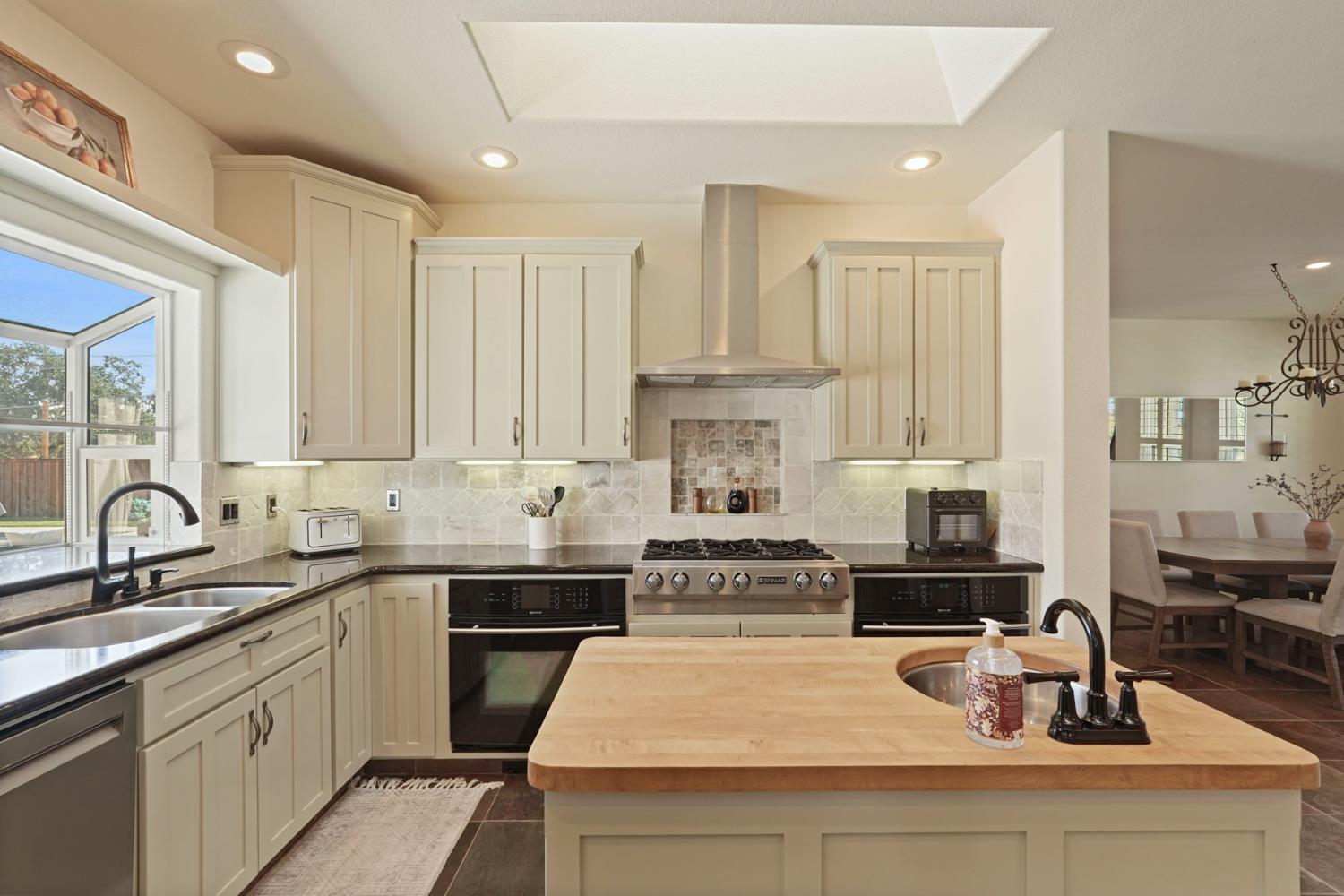8779 Ospital Road Valley Springs, CA 95252 - Photo 27 of 80 a kitchen with kitchen island granite countertop a sink stainless steel appliances and cabinets