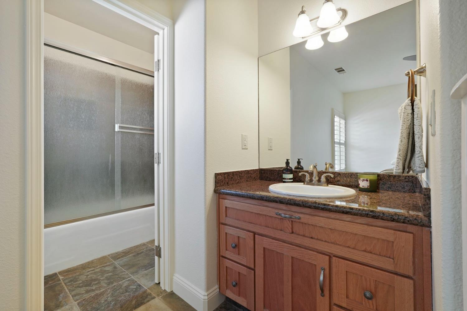 8779 Ospital Road Valley Springs, CA 95252 - Photo 42 of 80 a bathroom with a granite countertop sink and a mirror