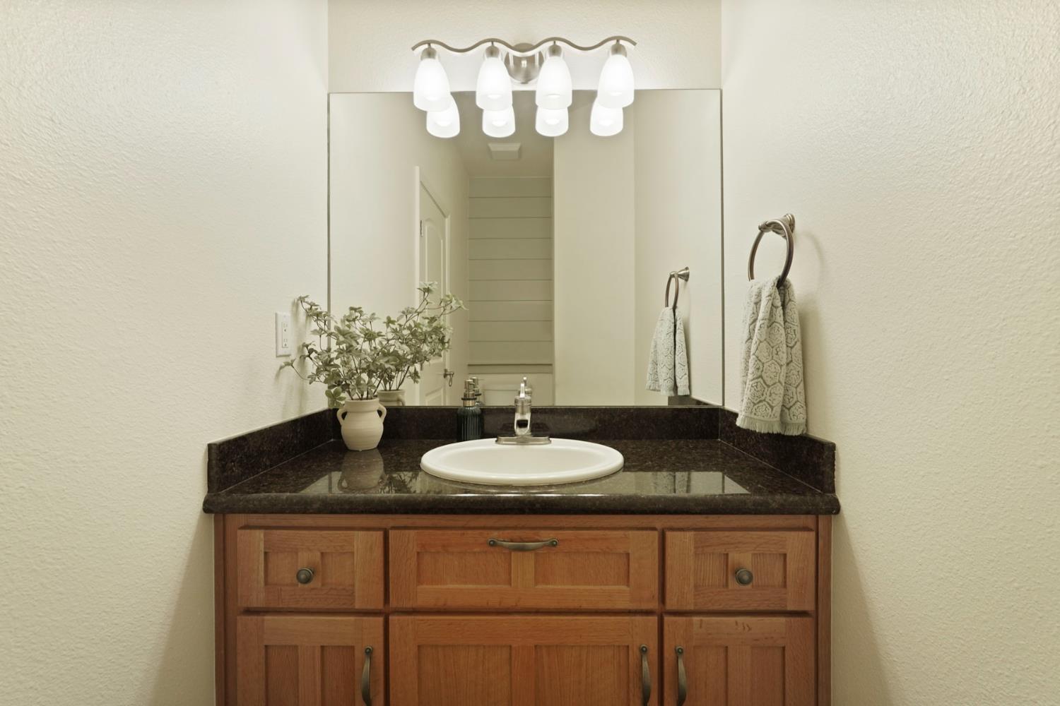 8779 Ospital Road Valley Springs, CA 95252 - Photo 52 of 80 a bathroom with a granite countertop sink and a mirror