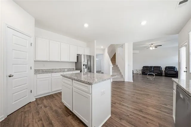 a kitchen with kitchen island white cabinets and stainless steel appliances