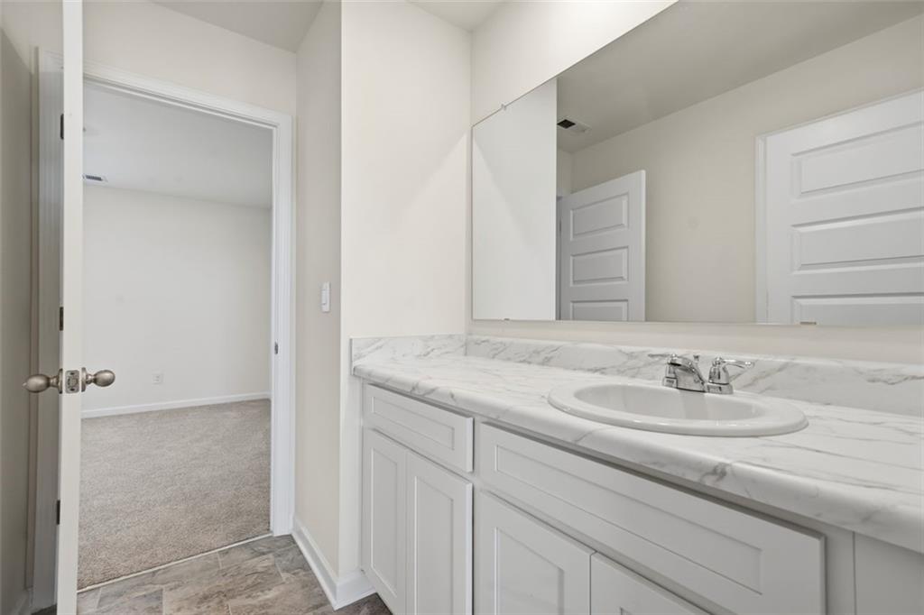 469 Ralph Still Road Dacula, GA 30019 - Photo 22 of 42 a bathroom with a granite countertop sink and a mirror