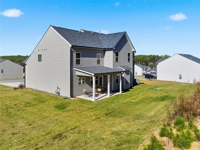 a view of house with backyard and trees