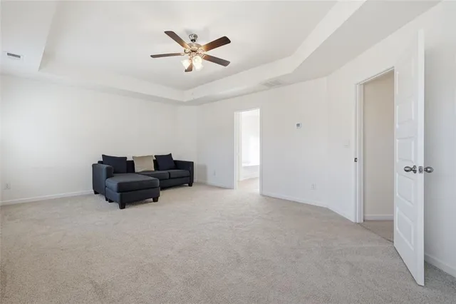 a living room with furniture and a ceiling fan