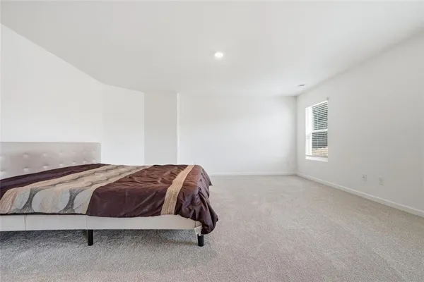 a spacious bedroom with a bed and a window