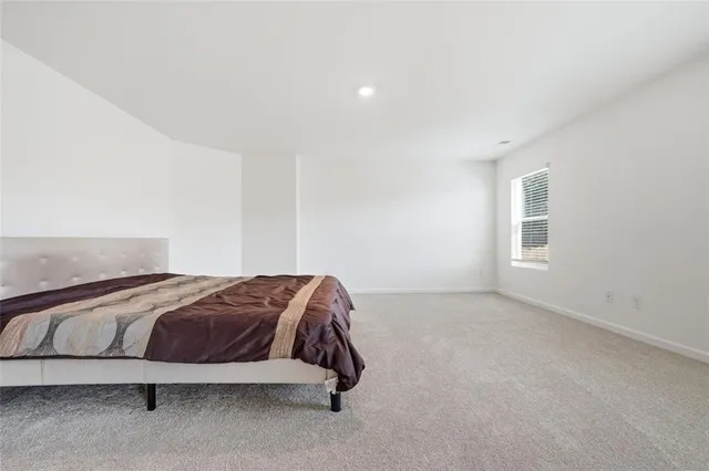 a spacious bedroom with a bed and a window