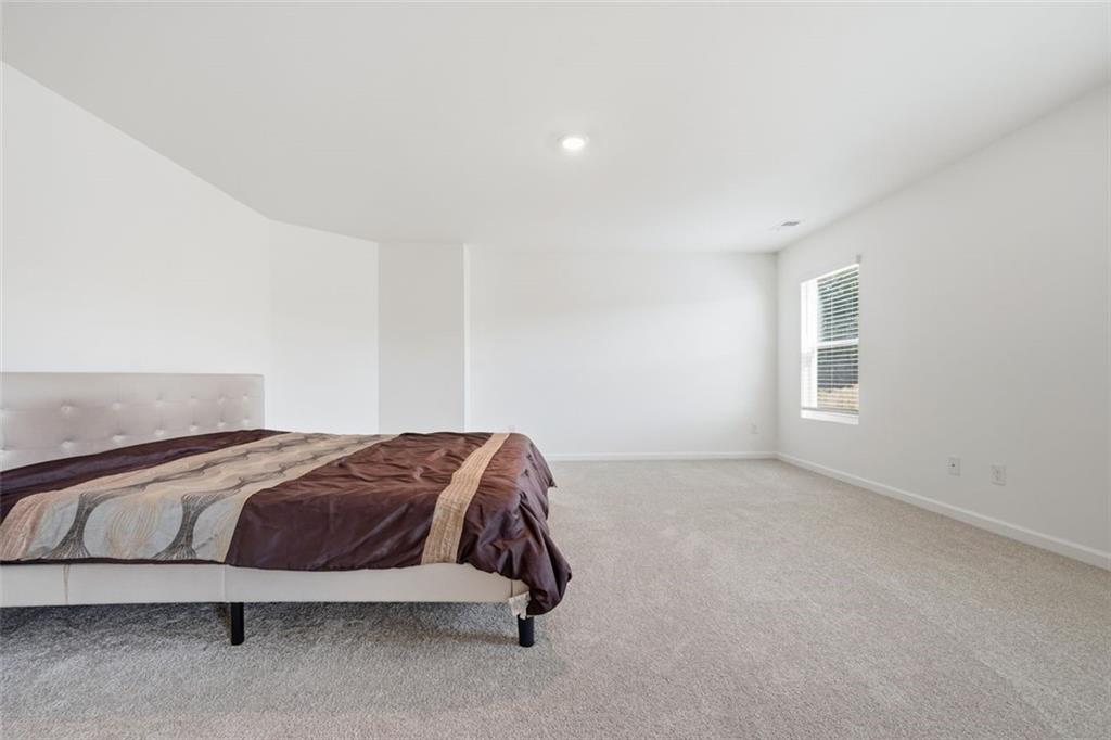 469 Ralph Still Road Dacula, GA 30019 - Photo 34 of 42 a spacious bedroom with a bed and a window
