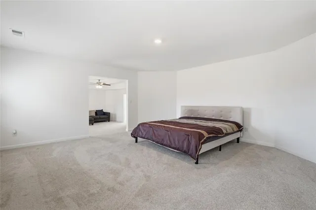 a spacious bedroom with a bed and cabinet