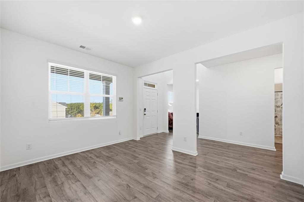 469 Ralph Still Road Dacula, GA 30019 - Photo 7 of 42 an empty room with wooden floor and windows