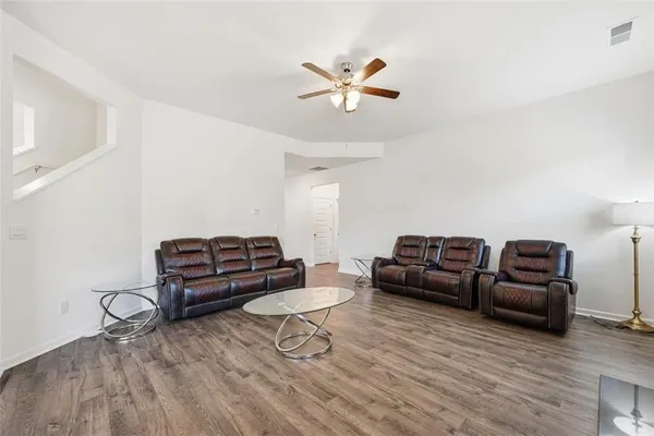a living room with furniture and a wooden floor
