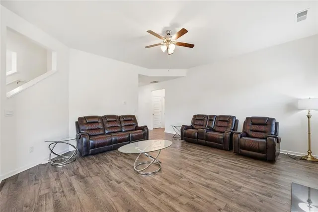 a living room with furniture and a wooden floor