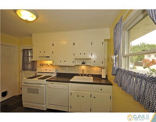3028 Cheesequake Road Old Bridge, NJ 08859 - Photo 4 of 16 a kitchen with stainless steel appliances white cabinets and a refrigerator
