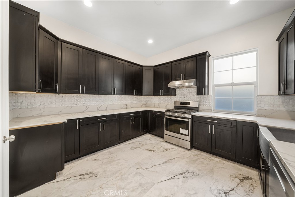 12210 Alamo Drive Rancho Cucamonga, CA 91739 - Photo 15 of 53 a kitchen with granite countertop wooden cabinets and black appliances