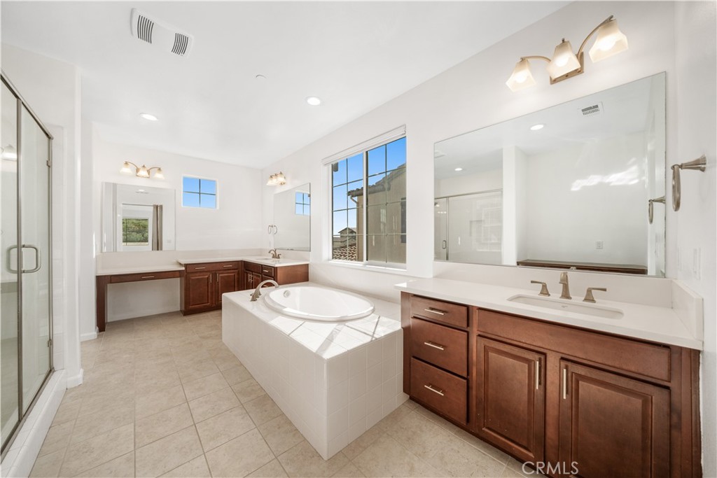12210 Alamo Drive Rancho Cucamonga, CA 91739 - Photo 24 of 53 a spacious bathroom with a double vanity sink mirror and bathtub